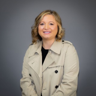 Young blond-haired woman wearing a tan jacket