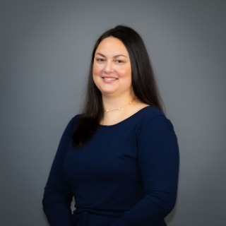 Long black-haired woman wearing a dark blue shirt