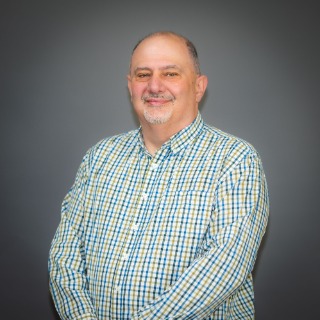 Older man wearing a white, blue, and green striped shirt