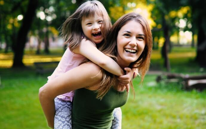 young woman and girl playing outside 